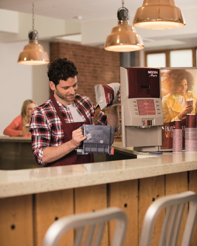 man refilling nescafe allegria machine